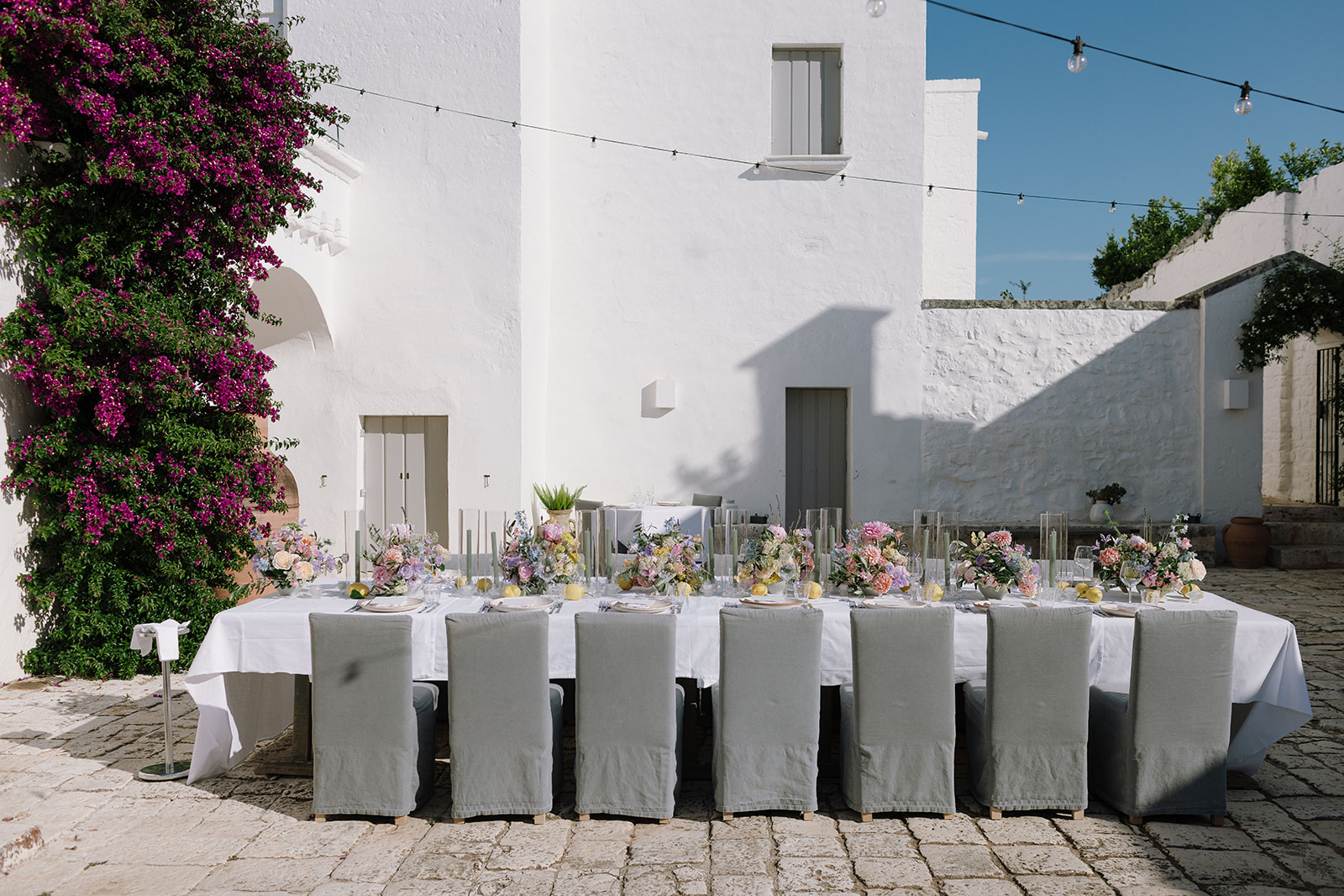 A sunlit table set in the courtyard at Masseria Petrarolo