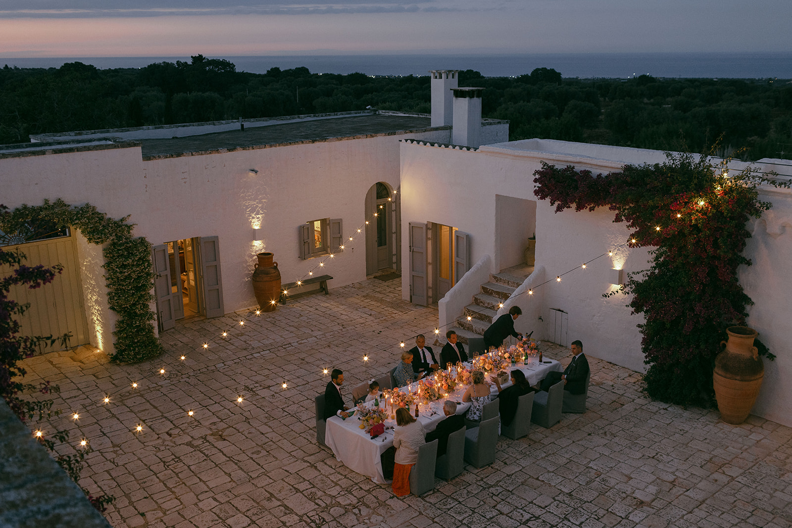 A wedding dinner in the candlelit courtyard at Masseria Petrarolo